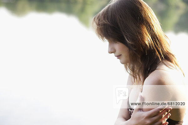 Portrait of young woman against lake