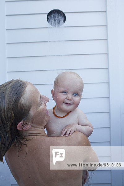 Mid adult woman having shower with her baby son (12-17 months)