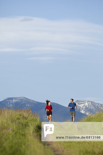 USA  Montana  Kalispell  Couple jogging in mountainside