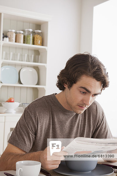 Mann  jung  Frühstück  Zeitung  vorlesen