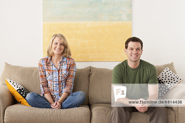 Smiling mid adult couple sitting on sofa
