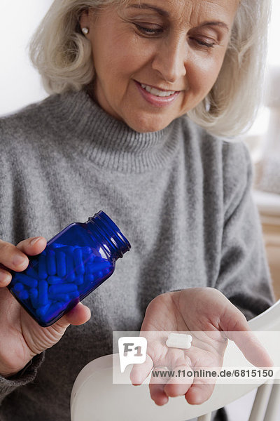 Senior woman holding medicine bottle