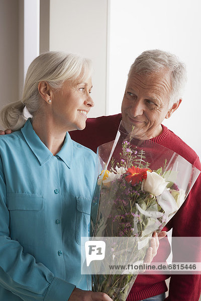 Senior couple  woman holding flowers