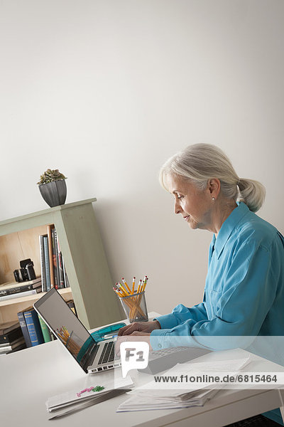 Senior woman working on laptop in home office