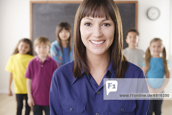 Teacher with group of pupils in front of blackboard
