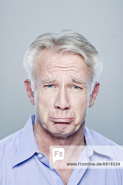 Portrait of senior man making sad face  studio shot