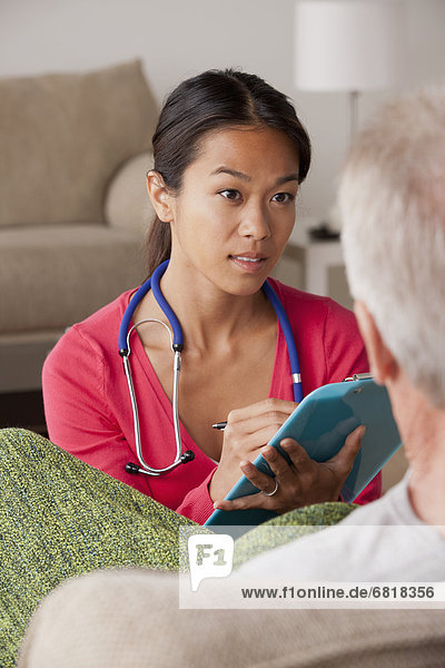 Female nurse with senior patient at home