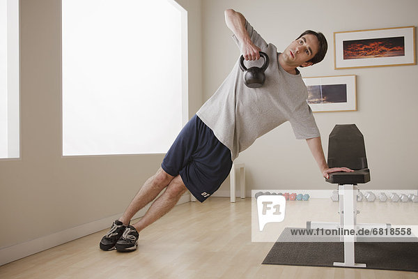 Young man exercising with weight
