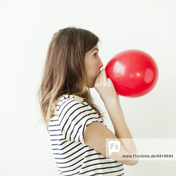 Frau  blasen  bläst  blasend  Luftballon  Ballon  jung  schießen  Studioaufnahme