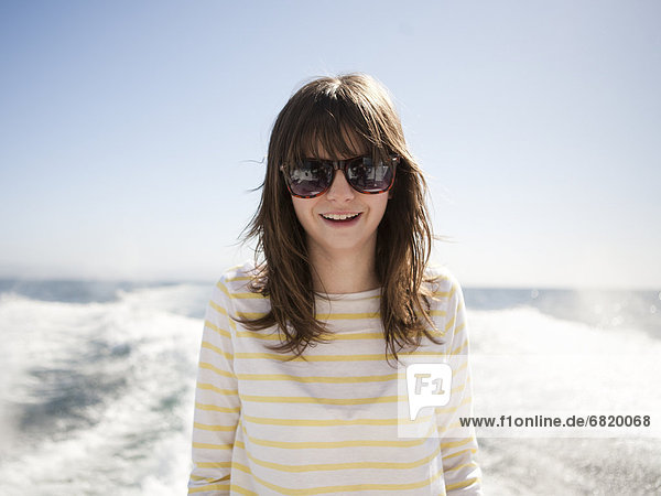 Portrait of young woman in sunglasses in front of sea