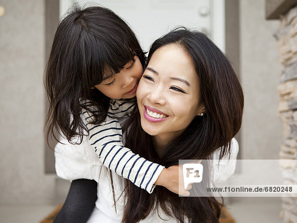 Smiling woman embracing by her daughter (4-5)