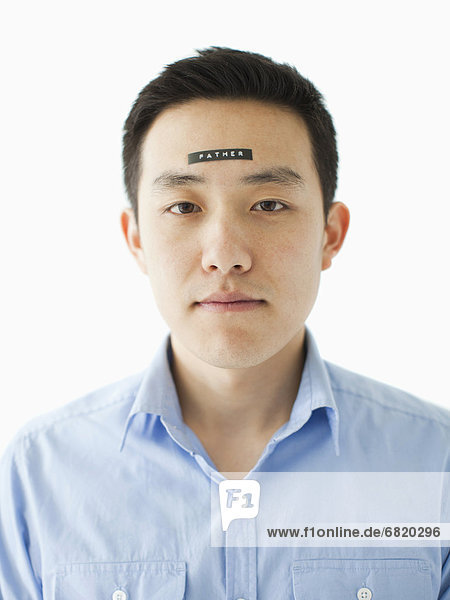 Portrait of young man with word 'father' on forehead  studio shot