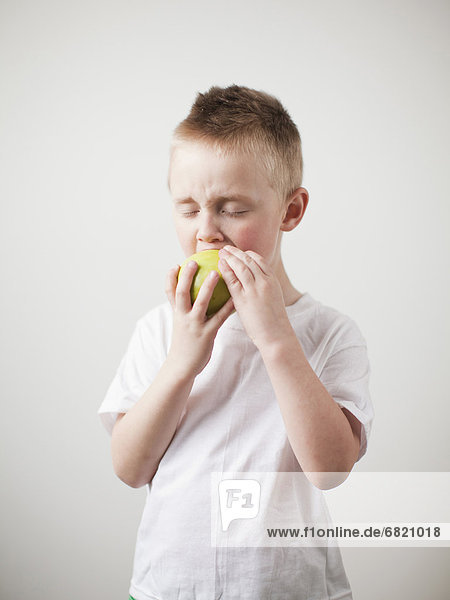 Portrait of toddler boy (2-3) devouring green apple