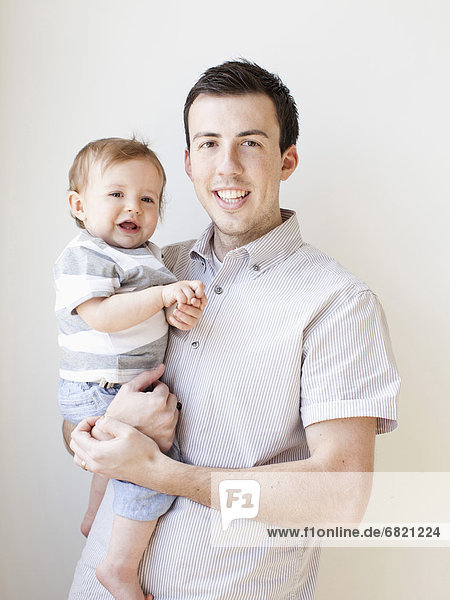 Father and baby boy (6-11 months) posing for portrait