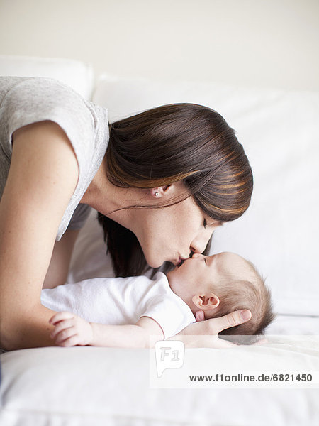 Mother kissing baby girl (2-5 months)
