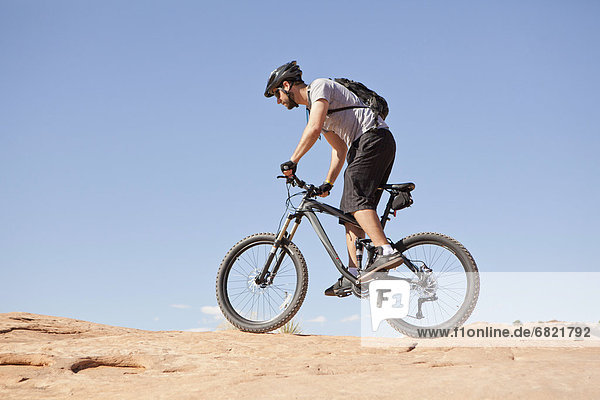 USA  Utah  Moab  Mid adult man riding mountain bicycle in remote scenery