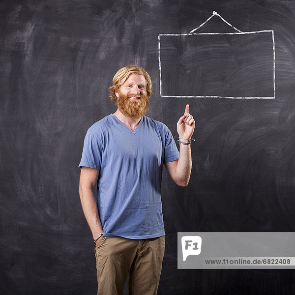 Man in front of blackboard with drawing depicting blank square