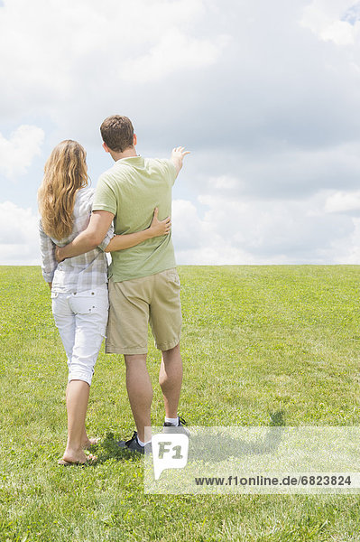 Couple standing on grass and embracing