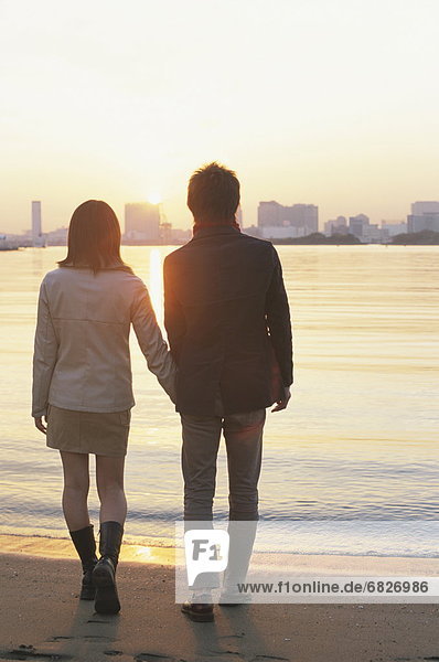 Young couple walking on beach  hand in hand