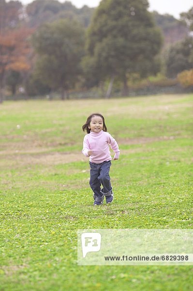 Young girl chasing a bubble in a park