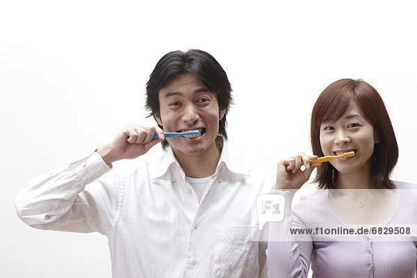 Couple brushing their teeth together