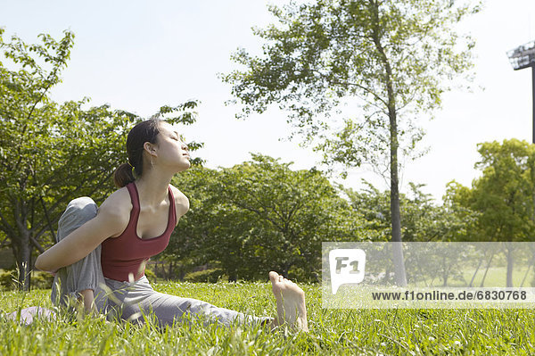 Young woman doing yoga at a park