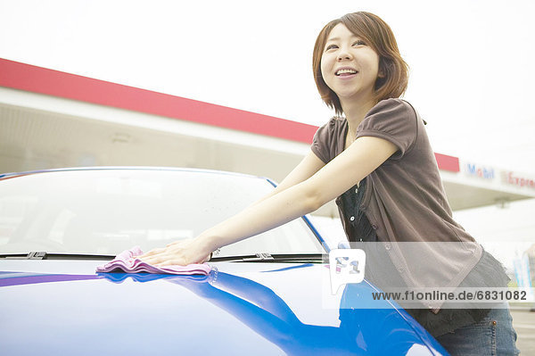 Young woman washing car  smiling