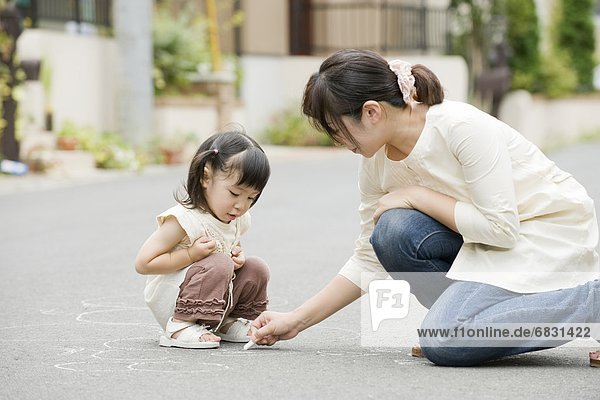 Mother and daughter playing on the street