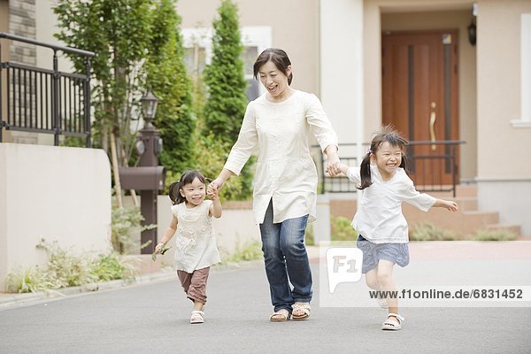 Mother holding hands with daughters and running