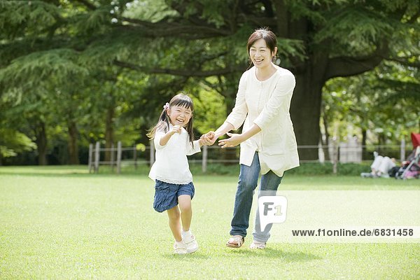 Mother holding hands with daughter and running