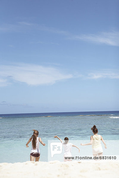 Young women running on beach  Guam  USA