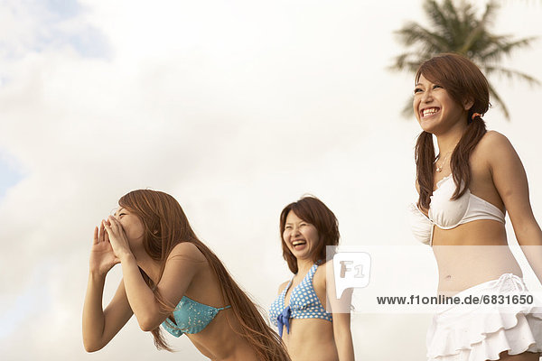 Young women shouting and laughing in bikini  Guam  USA