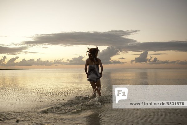 Young woman running into sea  Guam  USA