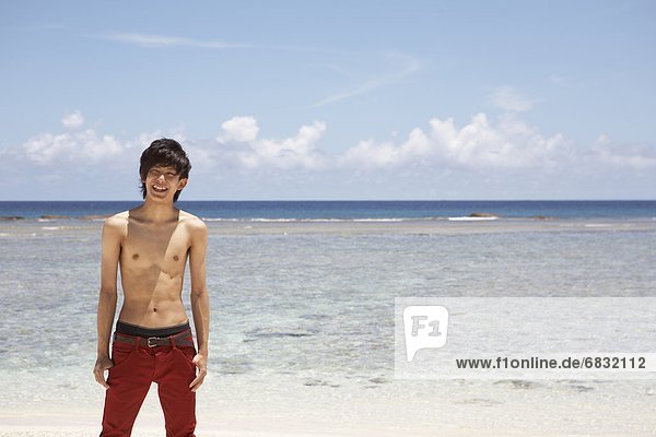 Young man standing on beach  Guam  USA