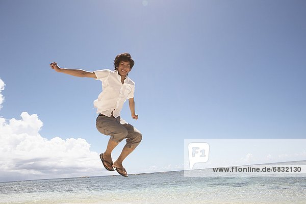 Young man jumping on beach  Guam  USA