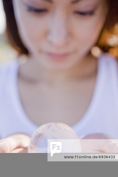 Young woman holding globe in hands  close up