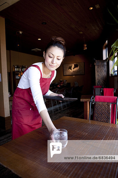 Mid Adult Woman Bringing Glass of Water at Table