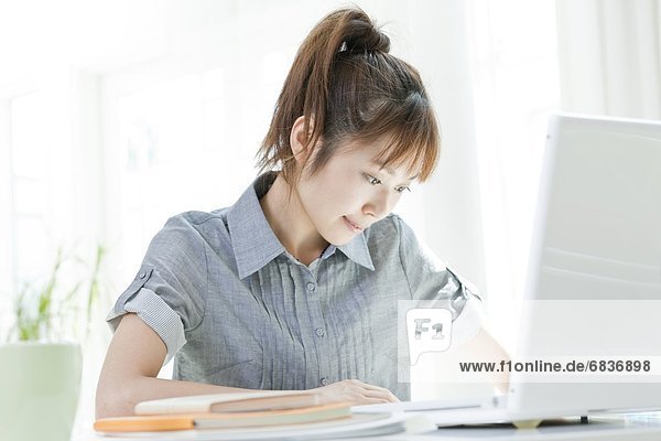 Young woman sitting at a desk and using a laptop