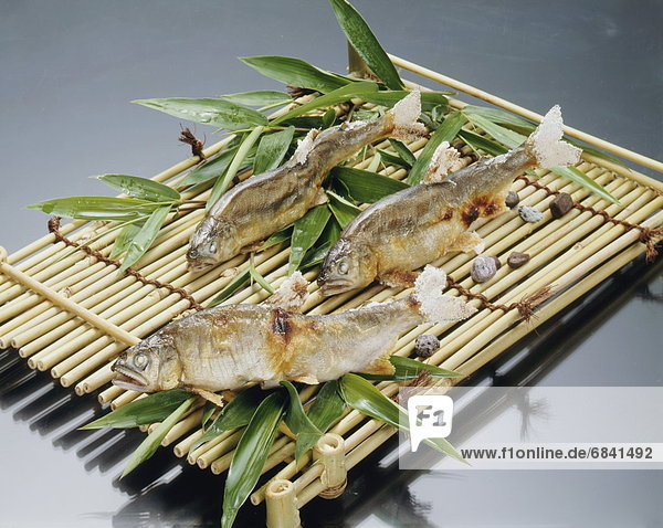Grilled fish on bamboo tray  black background