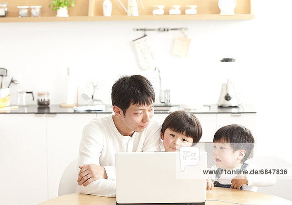 Father and sons using laptop