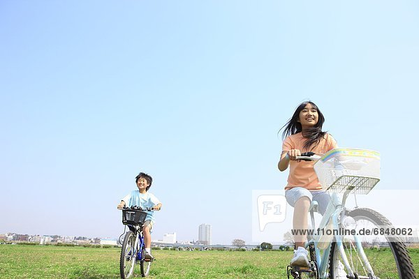 Siblings riding bicycles