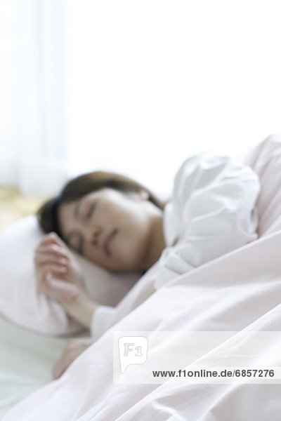 Young woman lying in bed asleep