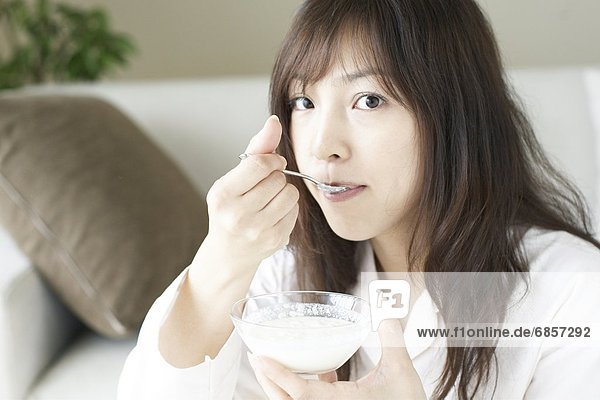 junge Frau junge Frauen Joghurt essen essend isst Frühstück