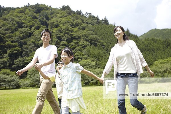 Japanese Family Walking Through a Park and Holding Hands