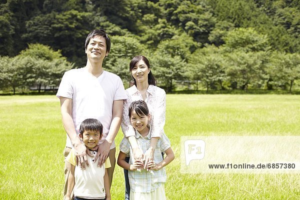Japanese Family Standing in a Park and Hugging