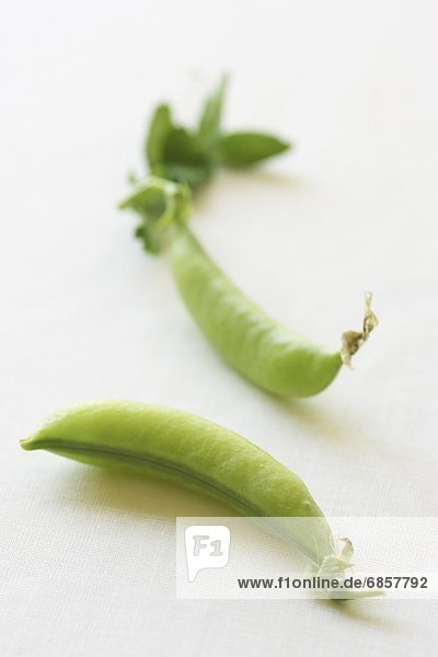 Two Green Pea Pods Lying Next to Each Other