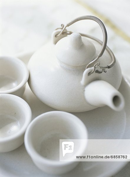 A White Teapot and Three Teacups