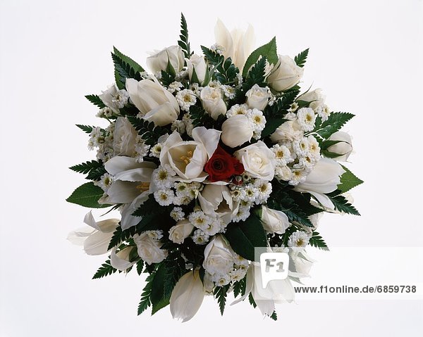 A round bouquet of white roses with a red one in the centre