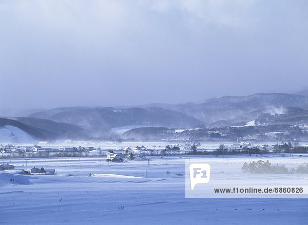 Rural Land Covered in Snow and Fog With Mountains in the Distance. Hokkaido  Japan