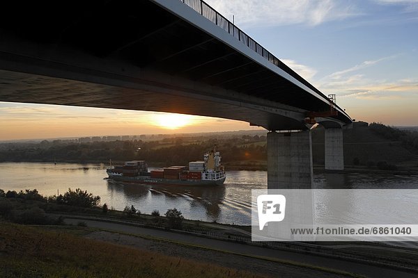 Sunset Over Bridge and Kiel Canal With Container Ship  Germany